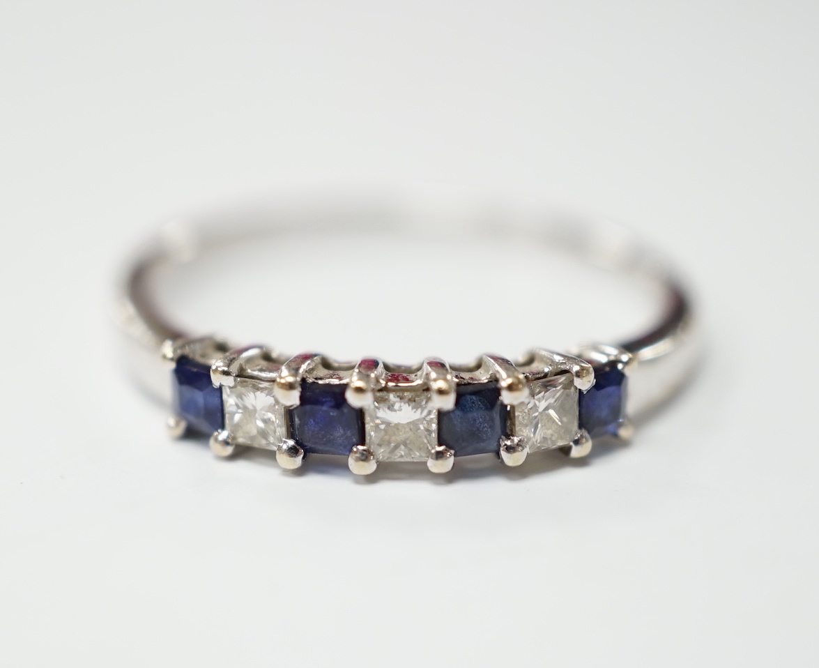 A modern 18k and plat, sapphire and diamond set seven stone half hoop ring, size O, gross weight 1.8 grams.